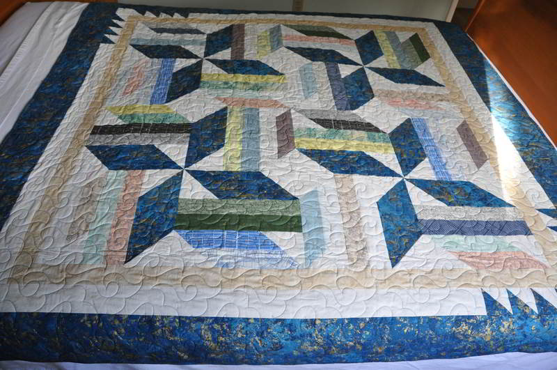 Quilt in metallic blue, white, yellows, pinks, greens and golds.