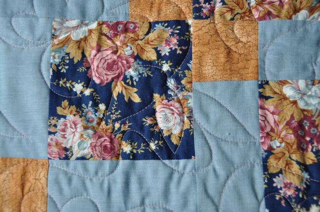 A look at the machine quilting done in a variegated dusty rose thread.