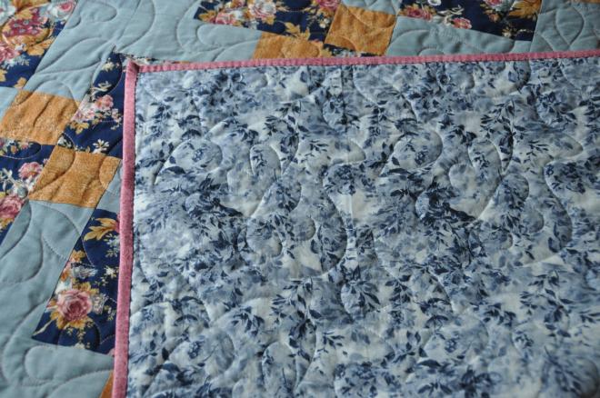 The blue and white backing fabric used in the quilt.