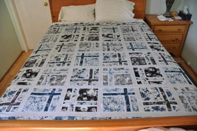 Quilt of floral patterned fabrics in blues and greys