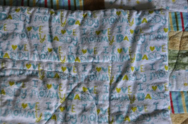 A blue on white flannel used for the backing. It is covered in the words 'I love Daddy I love Mommy'.