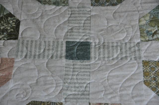 A close look the quilting pattern and one of the cross blocks joining the marigold blocks.