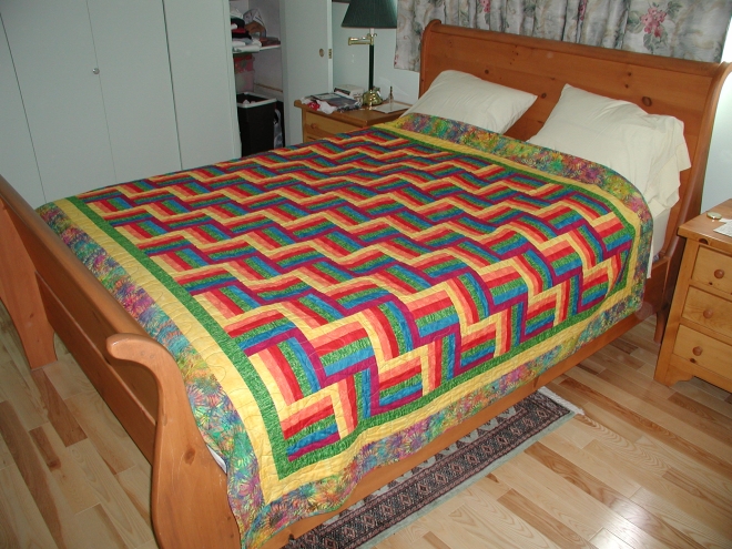 Fence rail pattern quilt in bright primary colours. Affectionately known as the harlequin quilt.