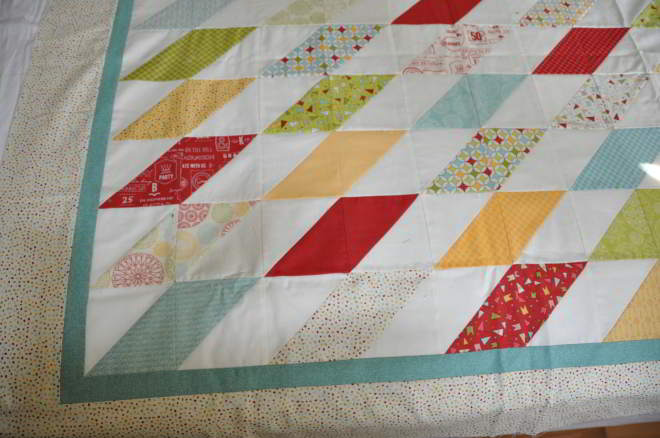 A shot of a corner, providing a closer look at the blocks and quilt top and border fabrics.