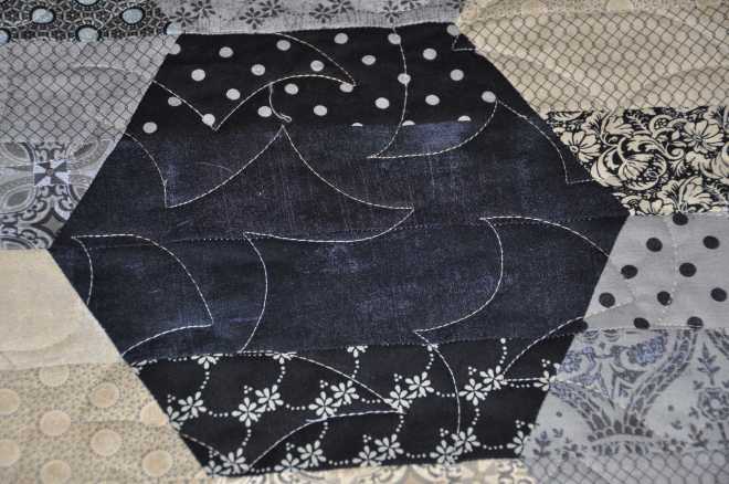 A close up of dark patch showing the quilt pattern, Any Which Way.