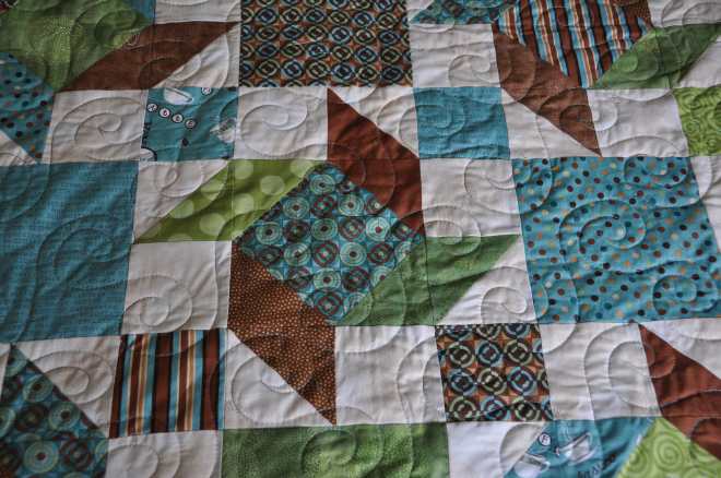 Close up of the almost bound Scrappy Windmills quilt from a kit bought in Lethbridge at Village Quilts.