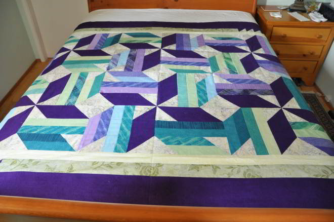 A shot from the bottom of the quilt on the bed shortside going top to bottom.