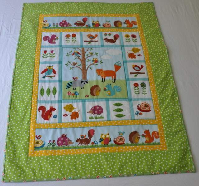 A baby quilt based on the Woodland Friends cotton panel by Northcott.